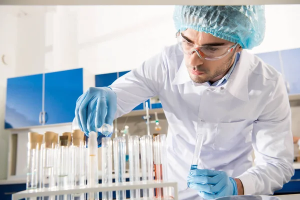 Trabajador de farmacia con tubos de ensayo — Foto de Stock