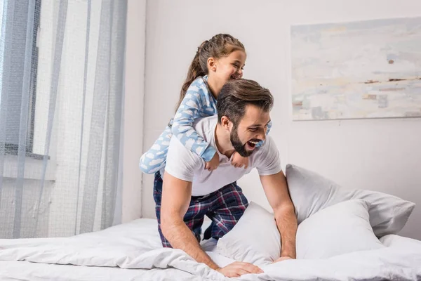 Far och dotter spelar i sängen — Stockfoto