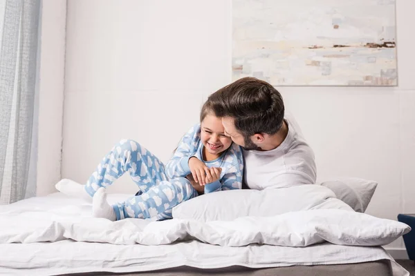 Vader en dochter knuffelen in bed — Stockfoto