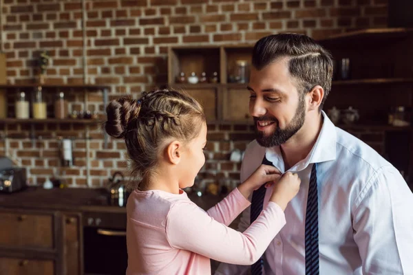 Daughter buttoning shirt for father — Stock Photo, Image