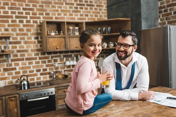 Father looking at daughter with juice in hands — Stock Photo, Image