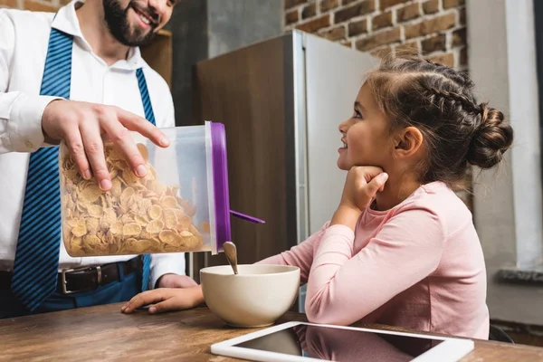 Padre haciendo desayuno de cereal para hija — Foto de Stock