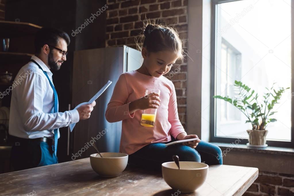 father and daughter on kitchen at morning
