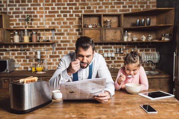 father and daughter eating breakfast together