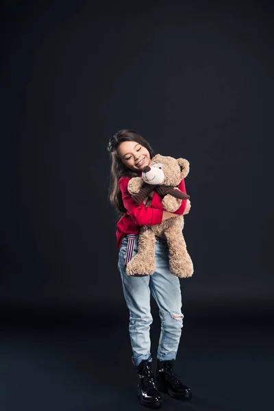 Glückliches Kind umarmt Teddybär — Stockfoto