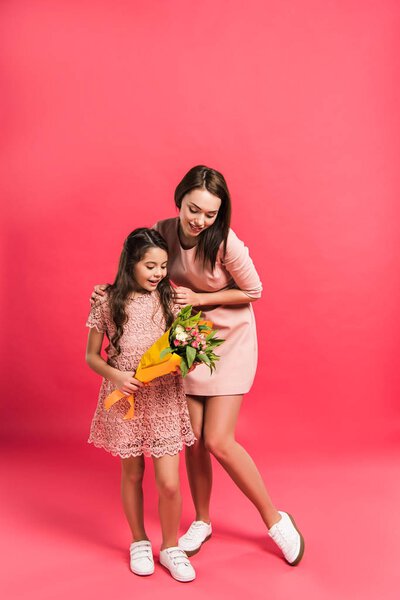 дочь смотрит на букет цветов
