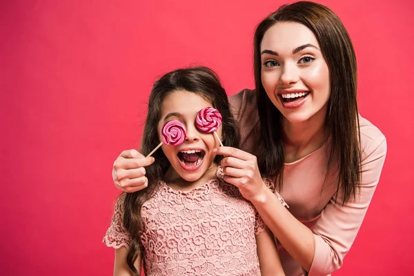 Madre cubriendo los ojos de la hija con piruletas —  Fotos de Stock