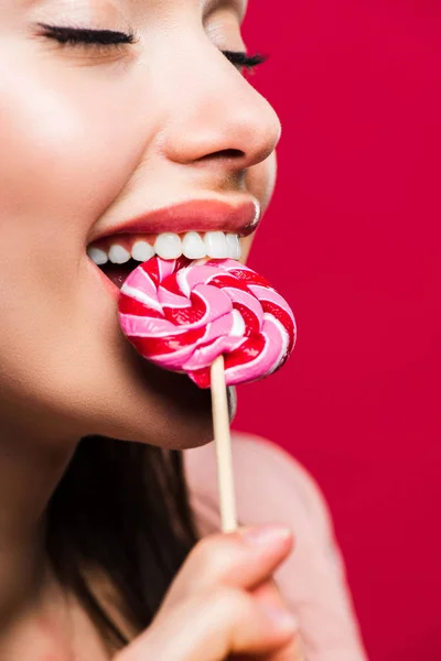 Woman biting colored lollipop — Stock Photo, Image