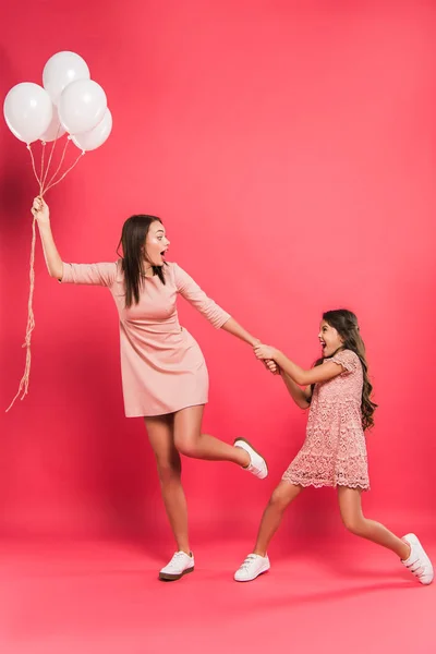 Dotter innehav mor med heliumballonger — Stockfoto