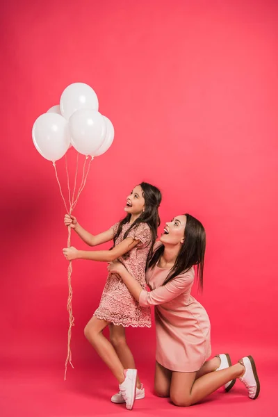 Filha e mãe olhando para balões — Fotografia de Stock