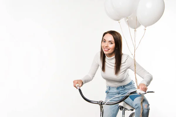 Woman sitting on bike with balloons — Free Stock Photo
