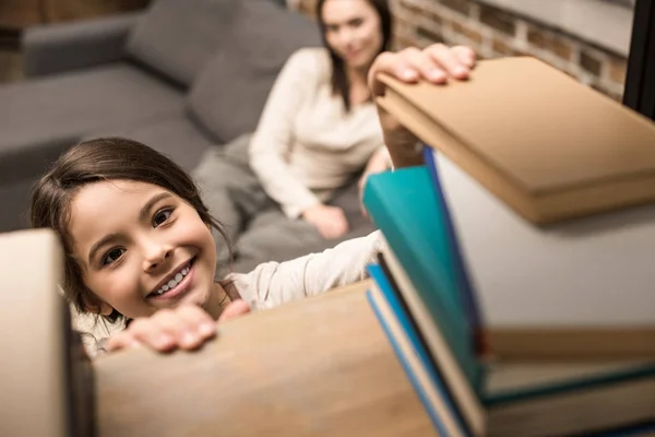Tochter holt Buch aus Bücherregal — Stockfoto