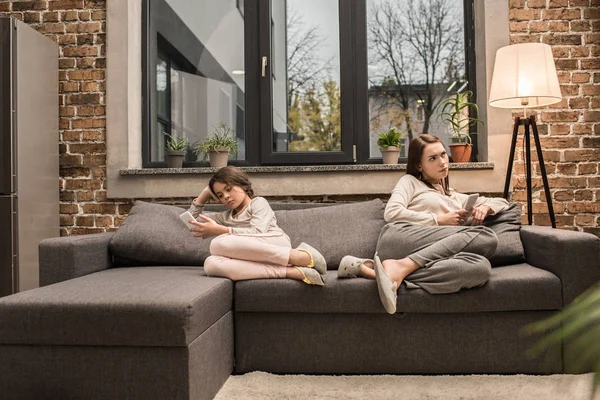 Familie met smartphones thuis — Stockfoto