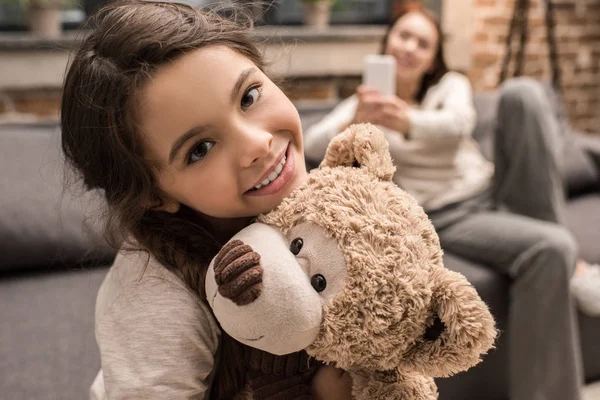 Дочка з плюшевим ведмедем вдома — стокове фото