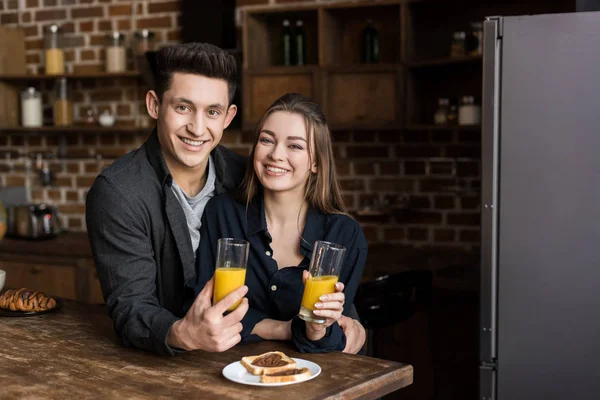 Lachende Paar Met Sinaasappelsap Camera Kijken — Stockfoto