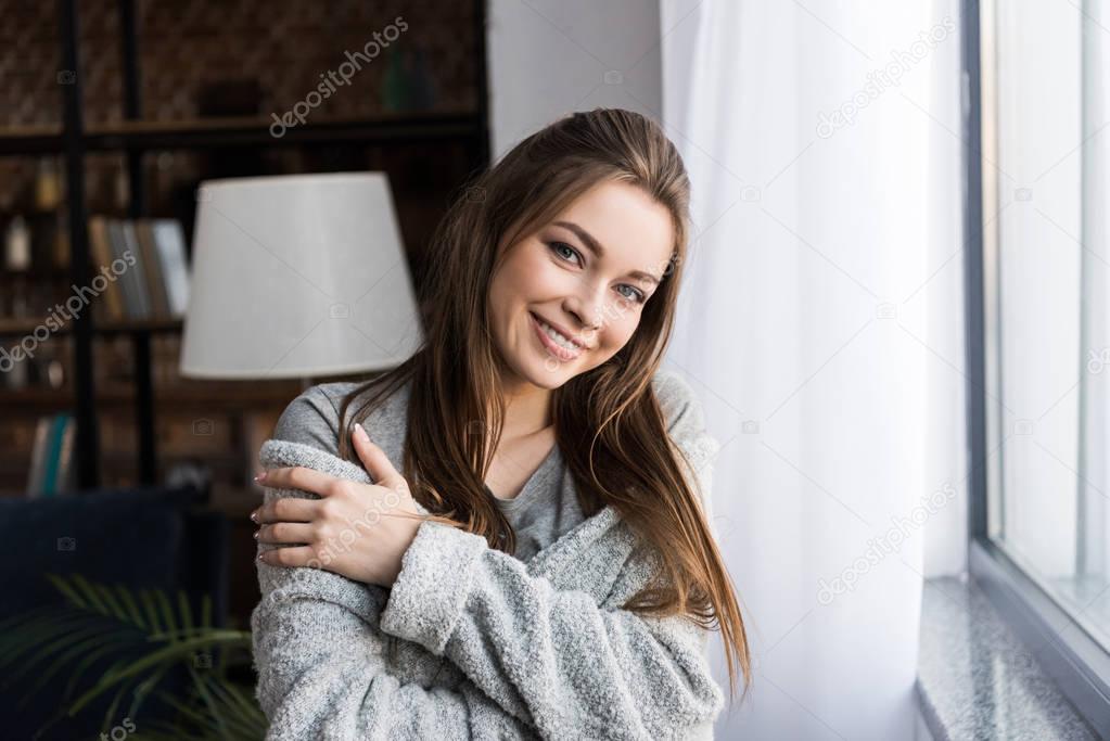 happy girl hugging herself and looking at camera