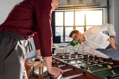 modern ofiste masa futbolu oynayan mutlu iş arkadaşları