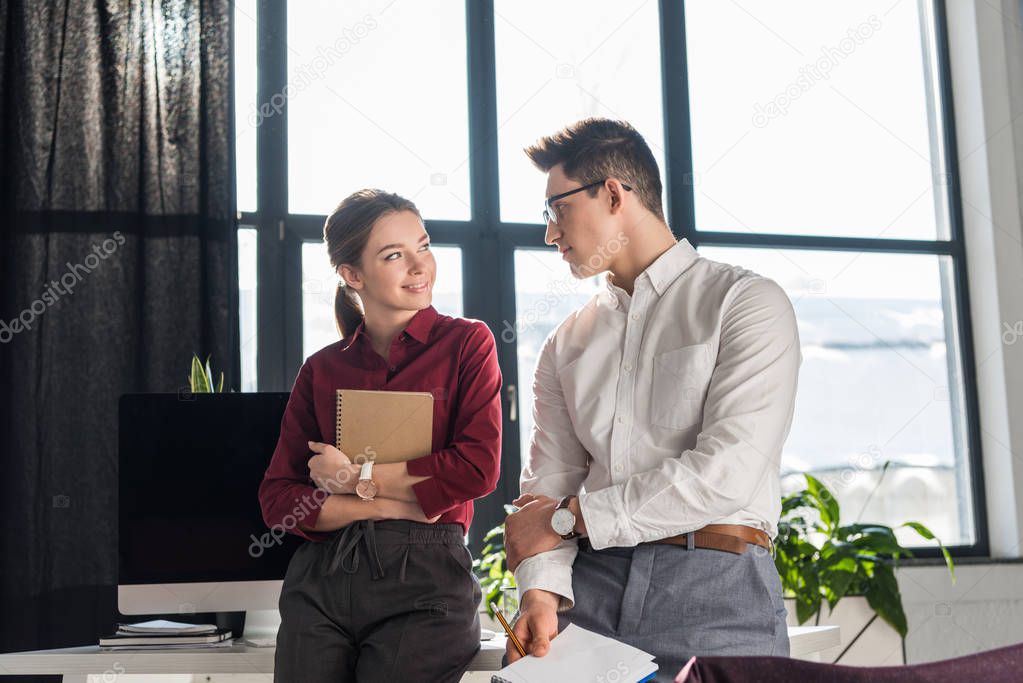 attractive young manageress flirting with her colleague, office romance concept
