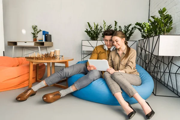 Feliz Joven Pareja Usando Tableta Juntos Mientras Están Sentados Bolsa — Foto de Stock