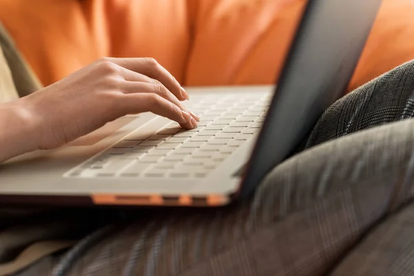 女性の膝の上のノート パソコンを使用してのトリミング ショット — ストック写真