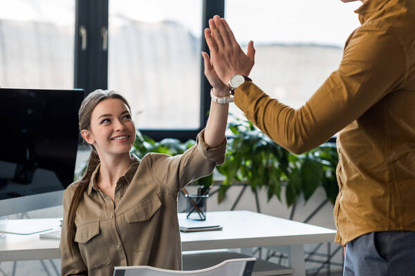 business partners giving high five at office