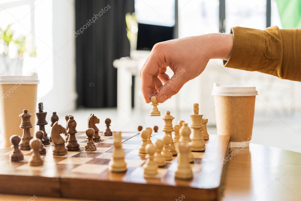 cropped shot of young man playing chess
