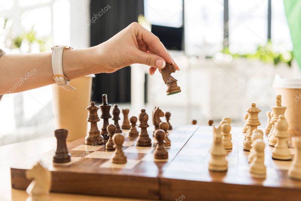cropped shot of young woman playing chess
