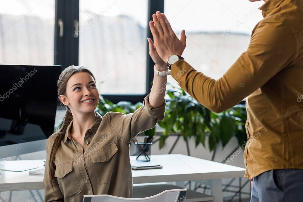 business partners giving high five at office