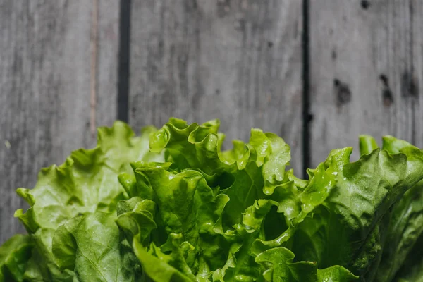 Feuilles de salade sur table en bois — Photo de stock