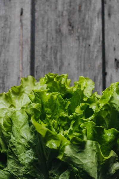 Feuilles de salade sur table en bois — Photo de stock