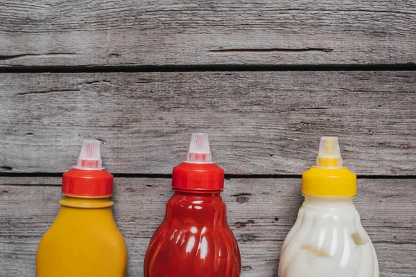 Sauces at bottles on wooden table — Stock Photo