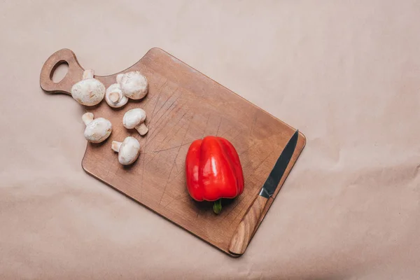 Bell pepper and mushrooms on wooden board — Stock Photo