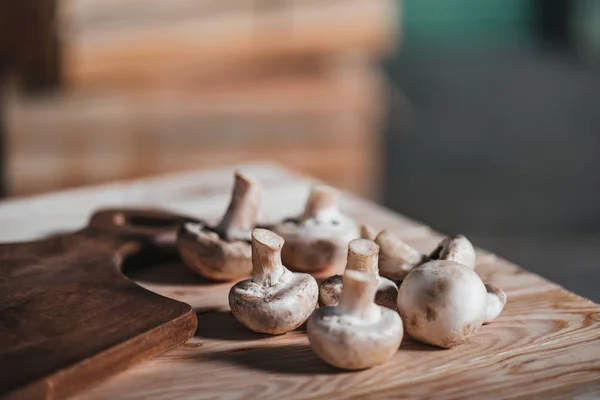 Mushrooms laying on wooden table — Stock Photo