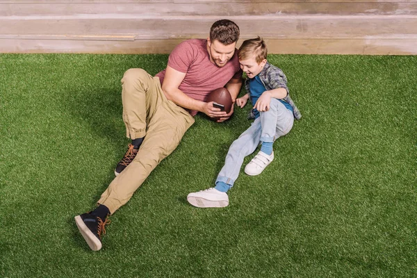 Pai com filho que põe na grama — Fotografia de Stock