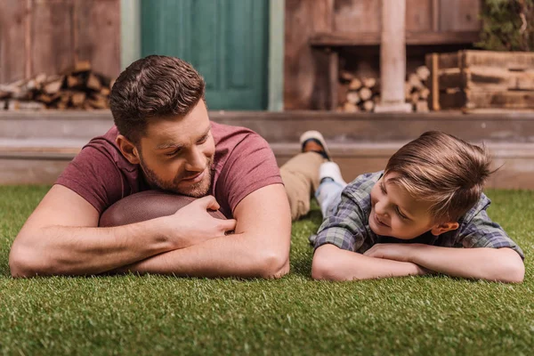 Padre con figlio adagiato sull'erba — Foto stock