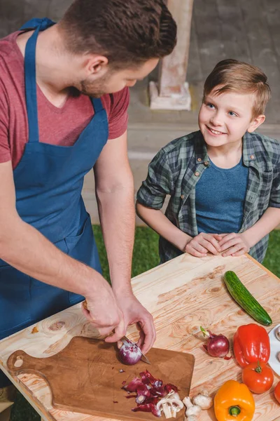 Padre con hijo preparando comida - foto de stock