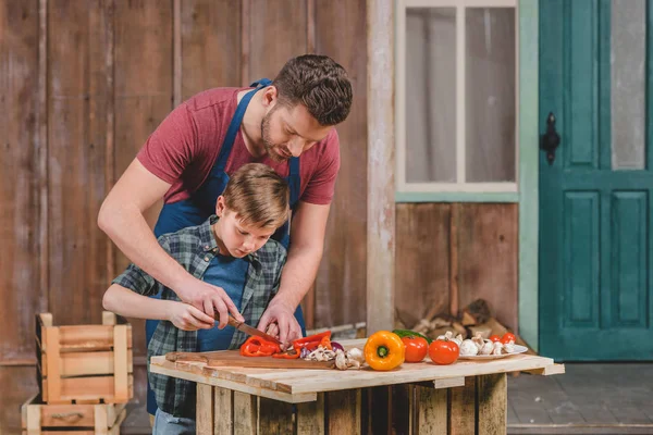 Father and son cutting vegetables — Stock Photo