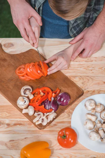 Padre e figlio tagliare verdure — Foto stock