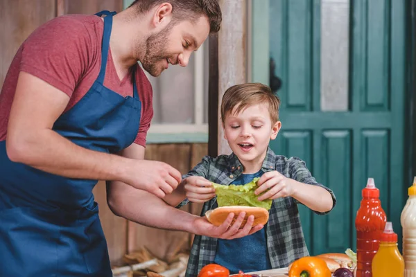 Pai e filho cozinhar cachorro quente — Fotografia de Stock