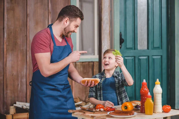 Father and son cooking hot dog — Stock Photo