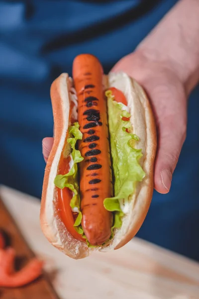 Hombre sosteniendo hot dog - foto de stock