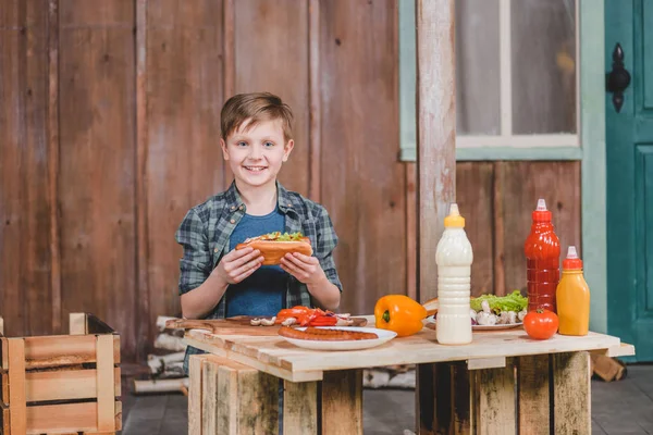 Niño sosteniendo hot dog - foto de stock
