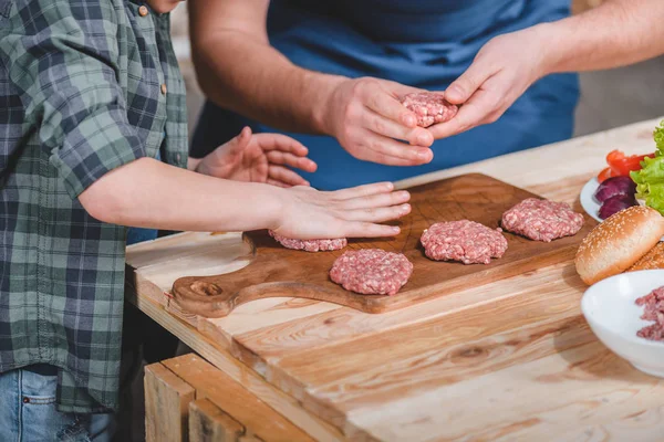 Pai e filho cozinhando hambúrgueres — Fotografia de Stock