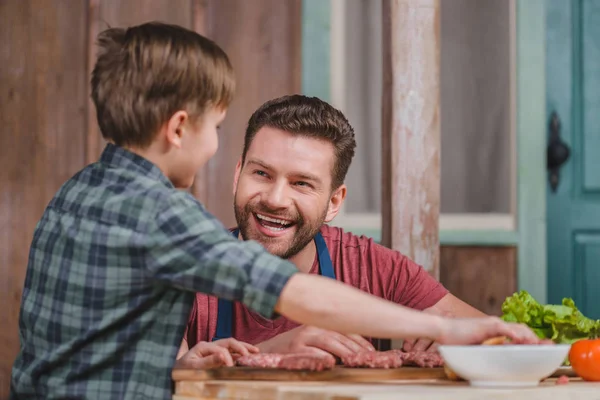 Dad and son cooking burgers — Stock Photo