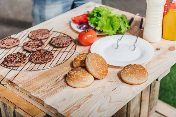 Ingredientes de hamburguesas en la mesa - foto de stock