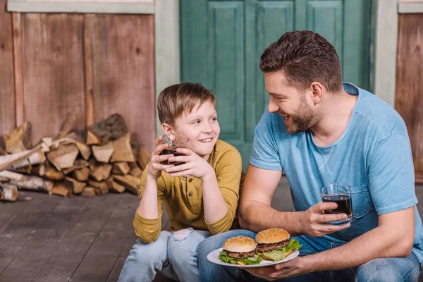 Padre e hijo con hamburguesas caseras - foto de stock