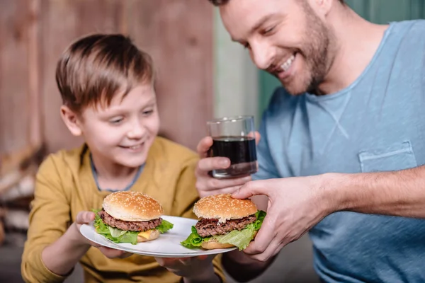 Padre e hijo con hamburguesas caseras - foto de stock