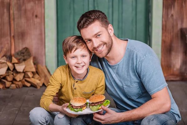 Pai e filho com hambúrgueres caseiros — Fotografia de Stock