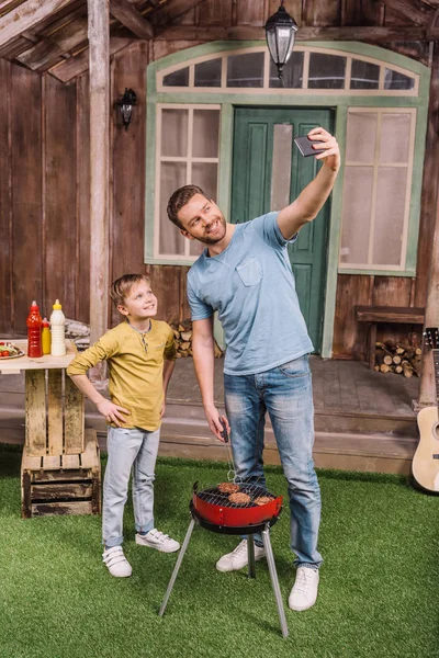 Padre e hijo tomando selfie - foto de stock