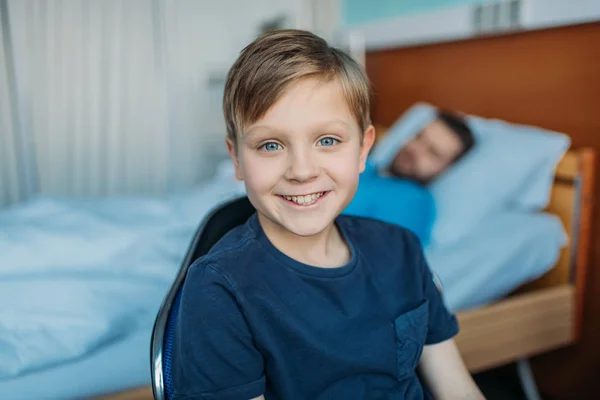 Son sitting near sick father at ward — Stock Photo